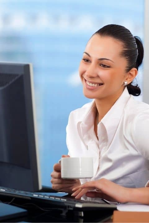 Girl taking medical coding course and smiling while drinking coffee
