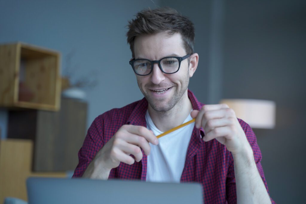 Smiling man looking at computer screen to help illustrate man taking online medical coding training